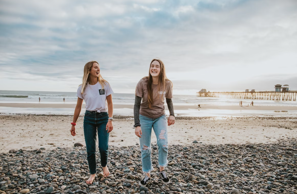 Smiling teenage girls by the beach.
